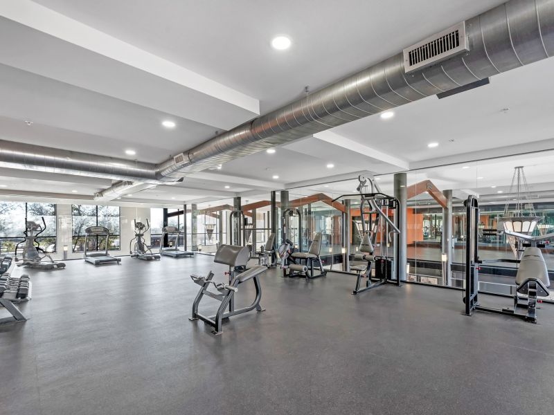 Modern fitness center at Gateway Cedars apartments with weight training equipment
