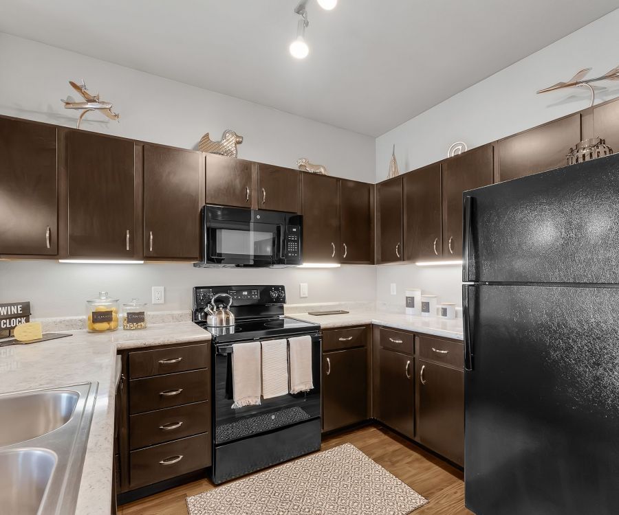 Gateway Cedars apartment designer kitchen with granite countertops and ample wood cabinets