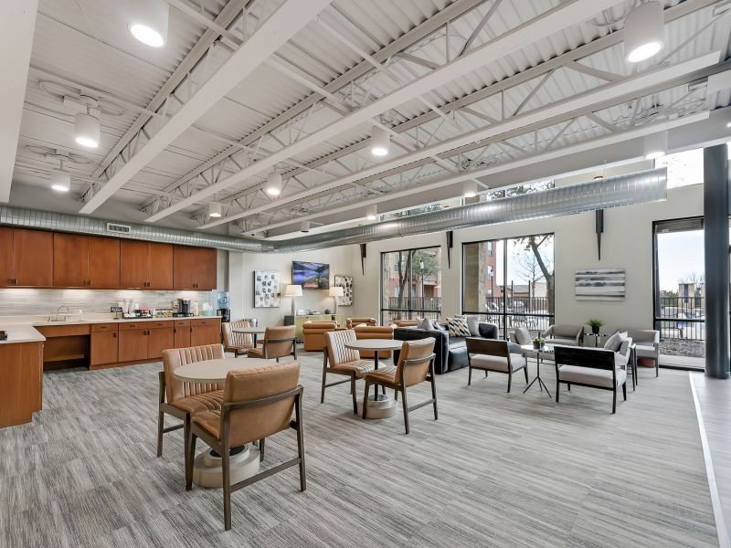 Gateway Cedars apartments community lounge with open floor plan and kitchen, furnished with chairs and sofas