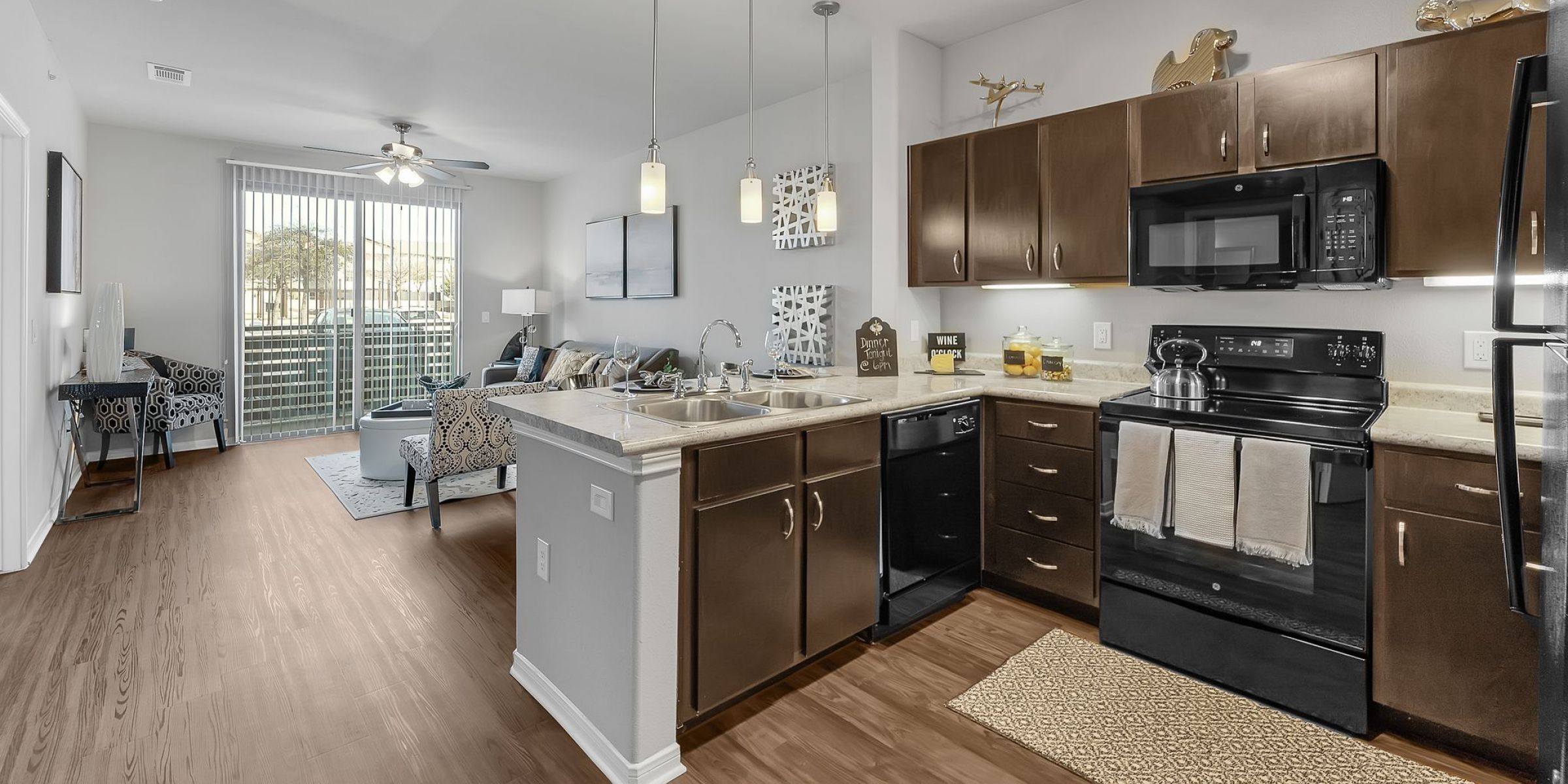 Luxury apartment living room with large windows, wood style floors and contemporary furniture at The Civic at Frisco Square